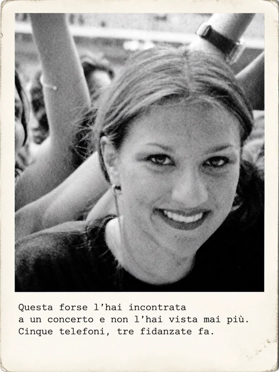 Una ragazza sorride verso l’obiettivo in mezzo al pubblico, con braccia alzate alle sue spalle.