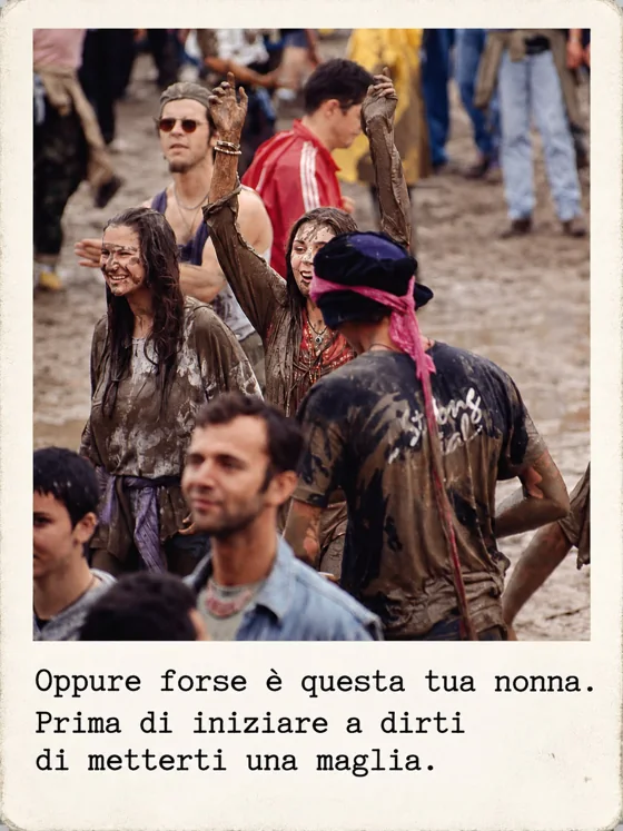 Ragazzi coperti di fango con le braccia alzate in un prato, durante un festival.