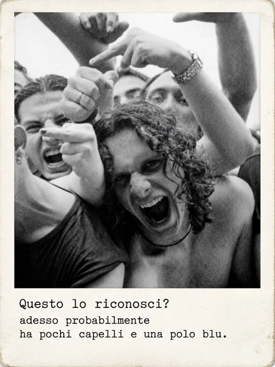 Un ragazzo con i capelli ricci urla verso l’obiettivo, stretto tra amici che fanno le corna.
