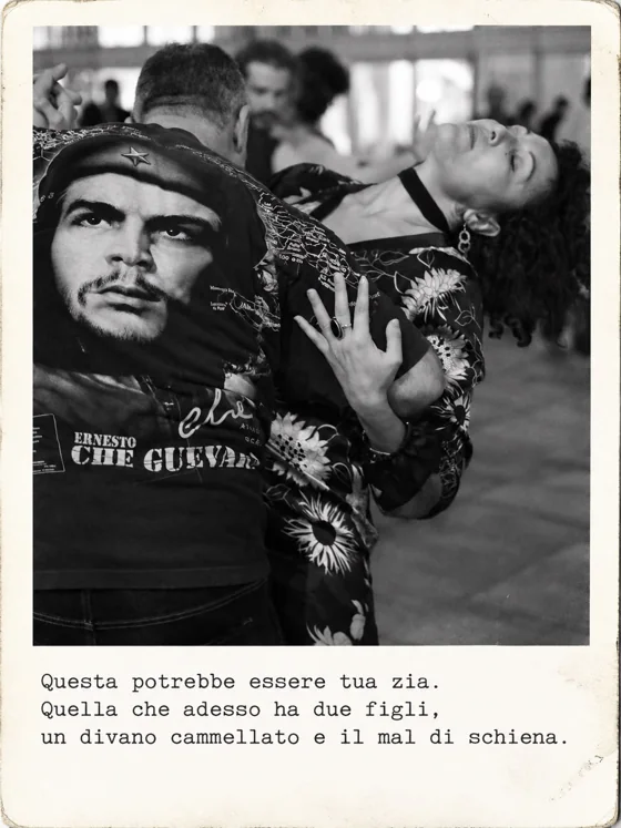 Una donna con il vestito a fiori balla a occhi chiusi abbracciata a un uomo con la maglietta di Che Guevara.