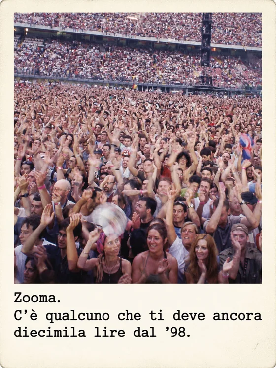 La folla di uno stadio vista dal palco, migliaia di persone con le mani alzate.